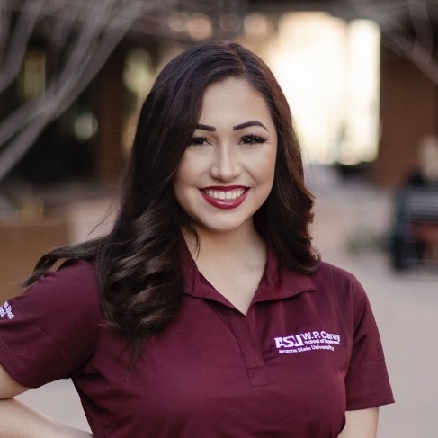 Alexis DeVries is a a young woman with long dark hair wearing a ASU Carey polo in ASU Maroon!